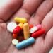 orange and white medication pill on persons hand